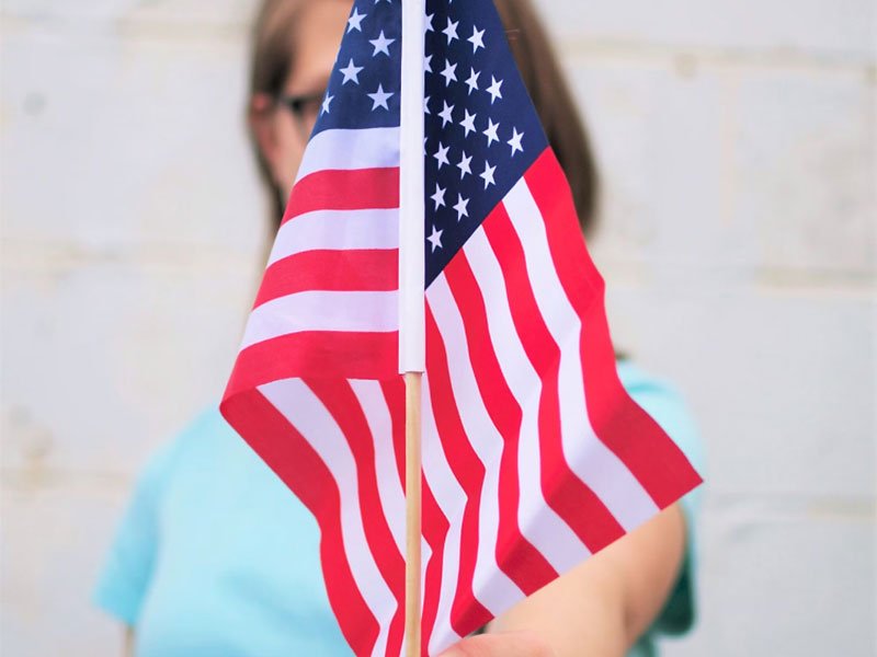 Person Holding Out USA Flag Person Holding Out USA Flag